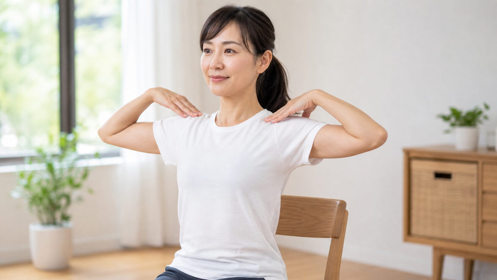 椅子に座って肩甲骨まわしのストレッチをする女性